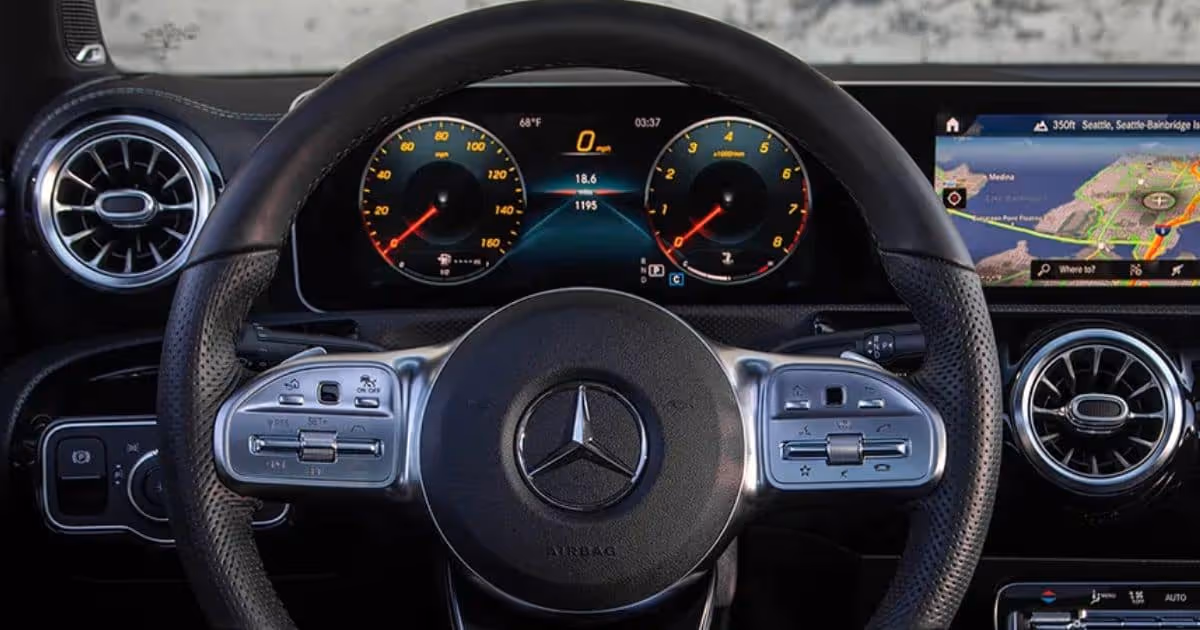 Close-up of a Mercedes-Benz steering wheel and modern digital dashboard display.